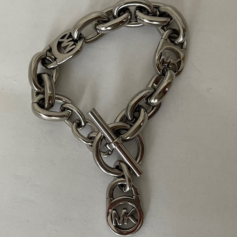 Michael Kors Polished Silver Tone MK Logo-Lock Bracelet.